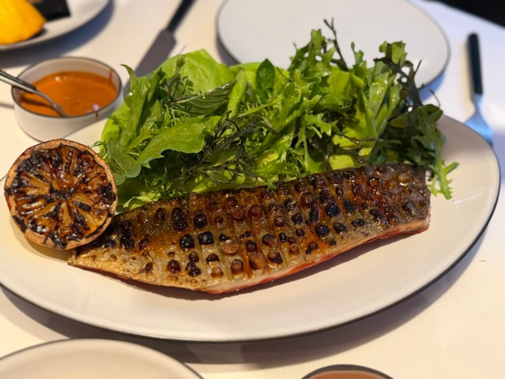 El zaguán que no anuncia nada Tikin Xic, pesca del día asada en recado rojo con ensalada, plato de Atte.
